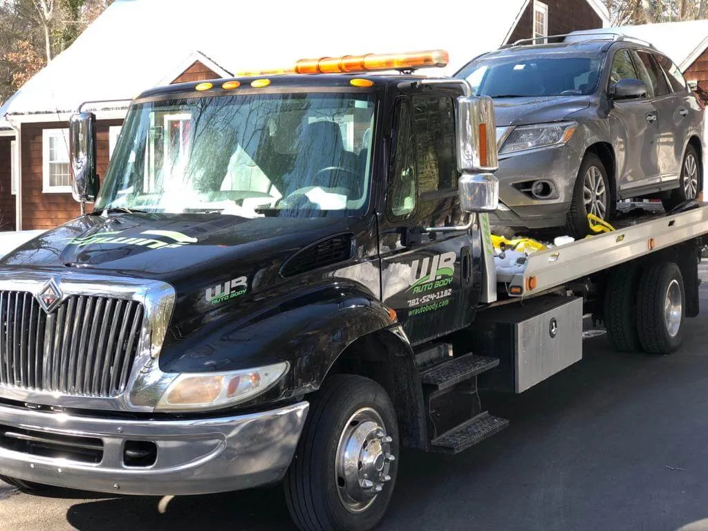 WR Auto Body tow truck carrying an SUV on its flatbed